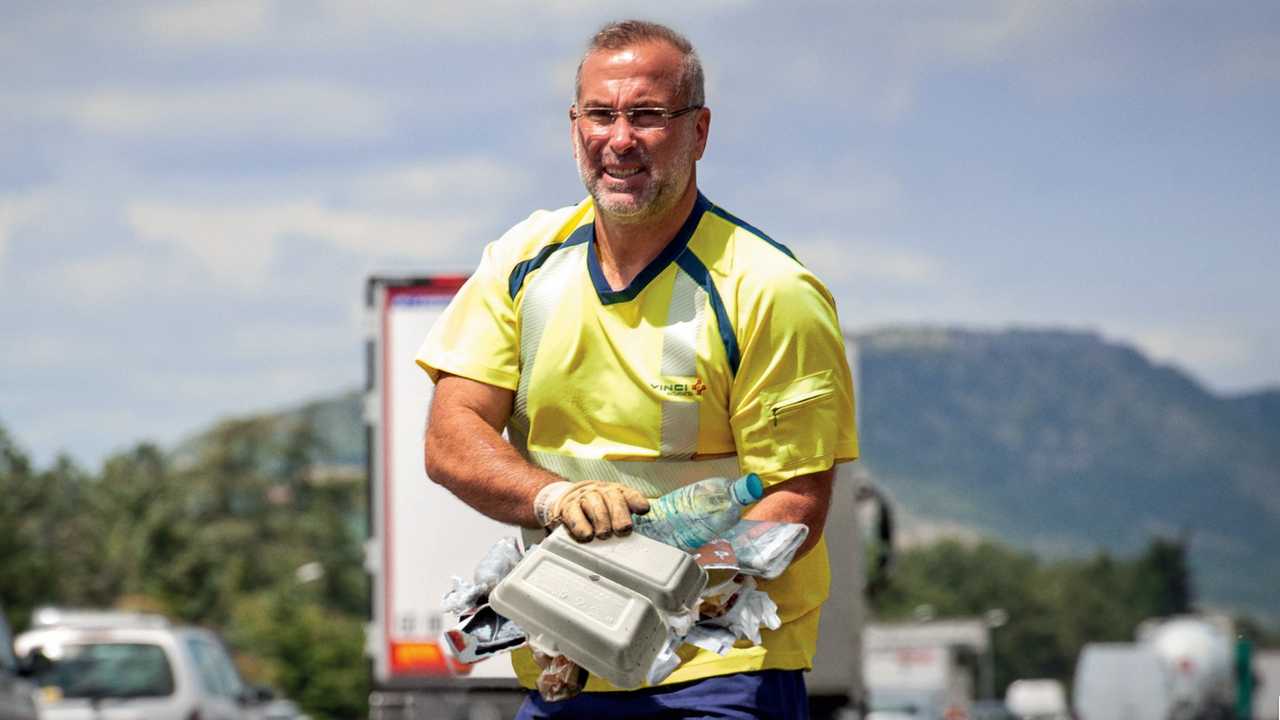 Agent d'autoroute ramassant des déchets sauvages